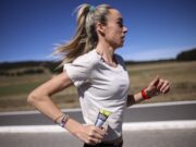 McColgan tackles gender gap in sports science Woman in white tshirt running along a road in what looks like a hot, sparse landscape. She's carrying a SiS gel