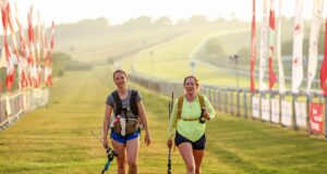 Two female walkers on the finish straight. The sun is low in the sky