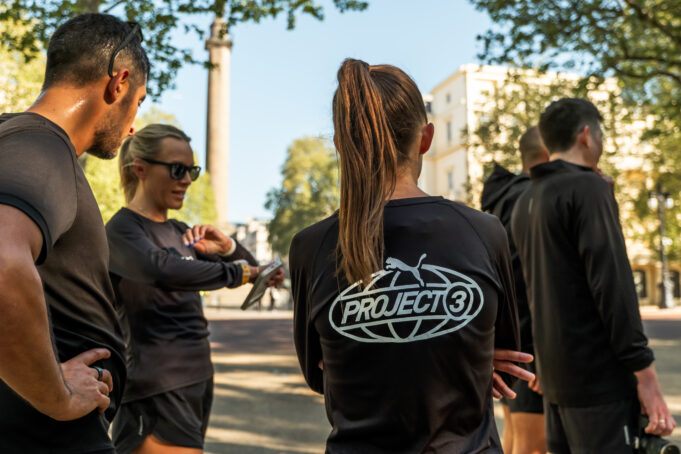 PUMA ICA 23 A group of people wearing black PUMA tshirts congregate on a street
