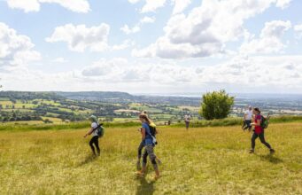 Iconic Peak District Ultra Challenge returns Three runners traverse a sunny field