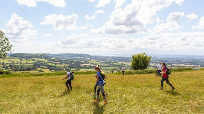 Peak-District-Ultra-Challenge-5-jpg Three runners traverse a sunny field