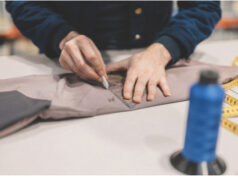 Photo of somebody cutting fabric on a table