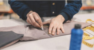 Photo of somebody cutting fabric on a table