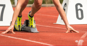 Close up of blonde woman in the starting blocks on a red track