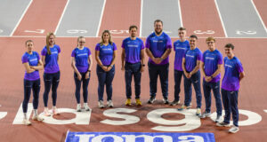 10 athletes stand on a track in Joma kit