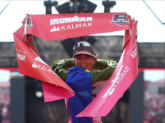 Philipp and Schomburg win IRONMAN Kalmar Triathlon Female triathlete grasps red finish tape above her head