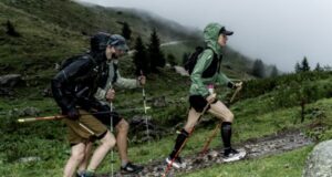 Two people walk up a hill in the rain