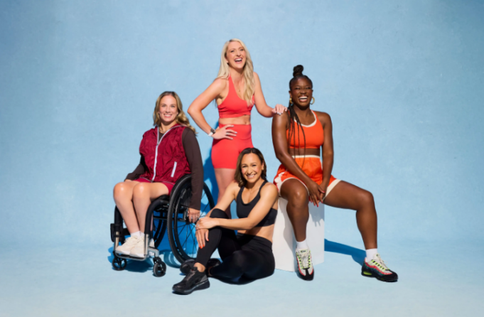 PhD Nutrition 4 women pose for a photo in theiir sports kit. One woman is in a wheelchair.