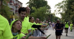 Supporters in bright yellow neon t-shirts line the streets full of runners