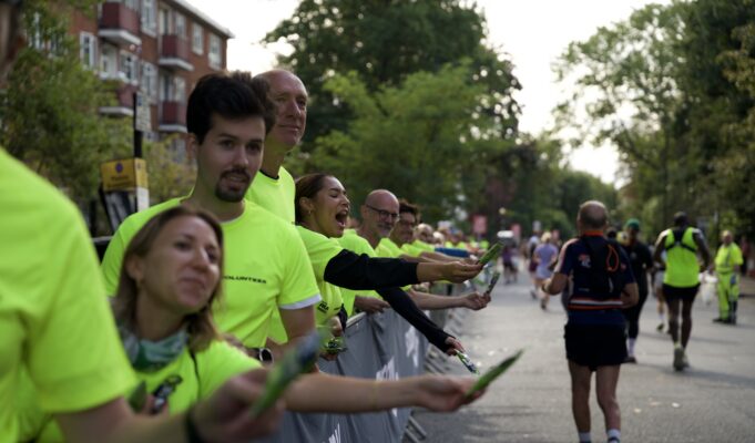 Supporters in bright yellow neon t-shirts line the streets full of runners