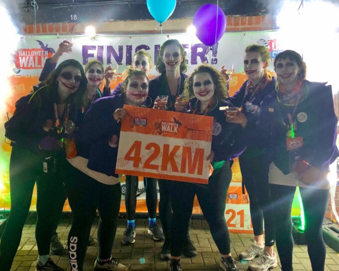 Halloween Walk 5 A group of runners in Halloween fancy dress hold a sign saying 42km