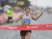 Call for Championship Entries – Great South Run Woman runs hard through red tape of a finish line