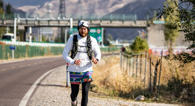 British runner Jack Jarvis crosses China on foot Man runs along side of a road with mountains in the background
