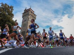 Ballot open for 2027 Cardiff Half Marathon A crowd of road runners running fast past a tower
