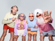 Britain’s oldest running team. Combined age: 321 4 runners in bright clothes, with grey hair, pose for the camera.