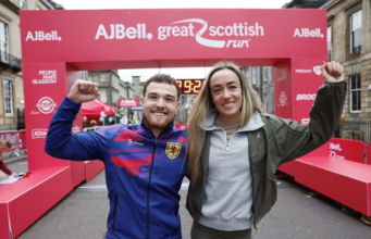 35,000 runners take part in Great Scottish Run Eilish McColgan and a young man stand in front of the start line, arms around shoulders, one arm each in the air, smiling